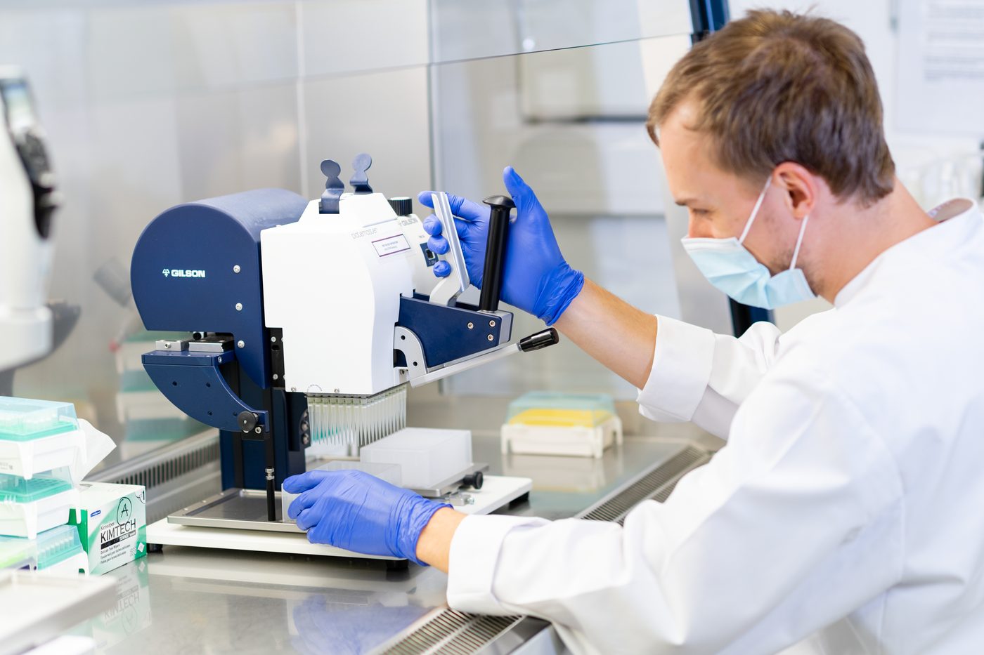 Laborant arbeitet an einem Pipettiersystem unter der Sicherheitswerkbank